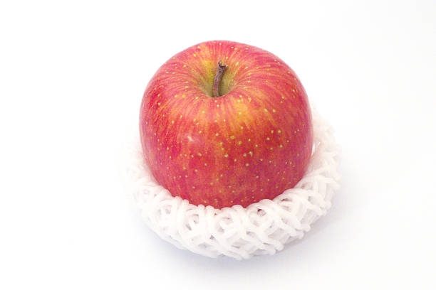 A red apple wrapped with a cushioning net with white background