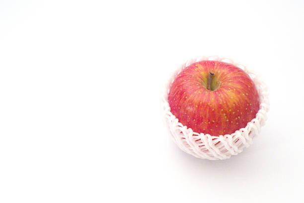 A red apple wrapped with a cushioning net with white background