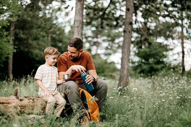 istock Father and son drinking tea in forest 2220569069
