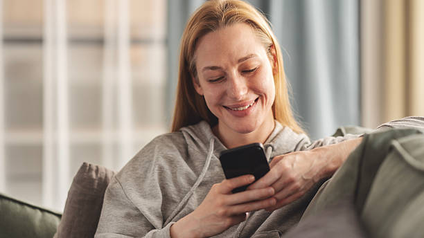 istock Young woman using mobile phone at home 2220570156