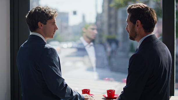 istock Two businessmen talking window cafe closeup. Partners making deal shaking hands 2220571234
