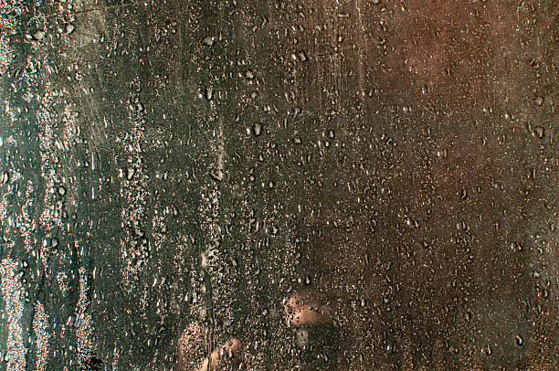 Car steamed window and raindrops. Rain symbol painted on glass.