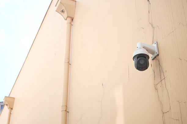 istock Security camera mounted on a cracked wall in a urban area 2220573602