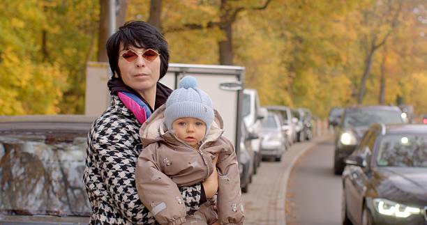 istock A woman is gently holding her baby while strolling through the autumn streets 2220573833