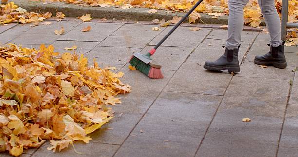 istock A person is diligently sweeping leaves off a paved surface during autumn 2220574160