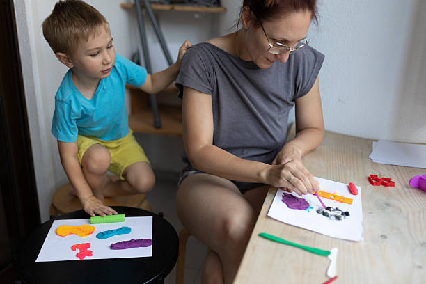 istock Mother and son creating colorful artwork with modeling clay at home 2220574855