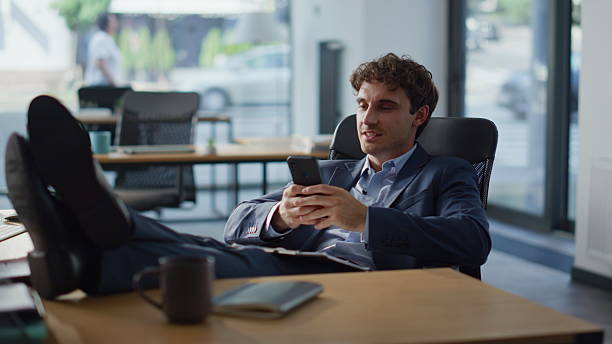 istock Office break man messaging mobile phone lying comfortable armchair alone closeup 2220575143