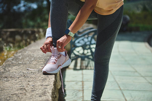 istock Woman Tying Running Shoe Laces Outdoors Before Exercising 2220575242