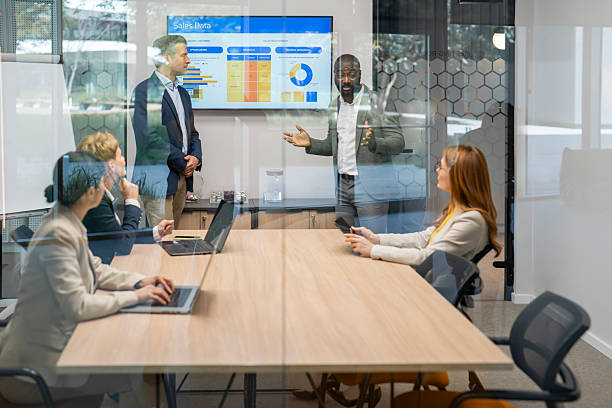 istock Managers presenting sales data to coworkers in office meeting 2220577354
