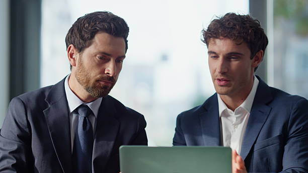 istock Talking partners looking laptop at panoramic cafe closeup. Business colleagues 2220577720