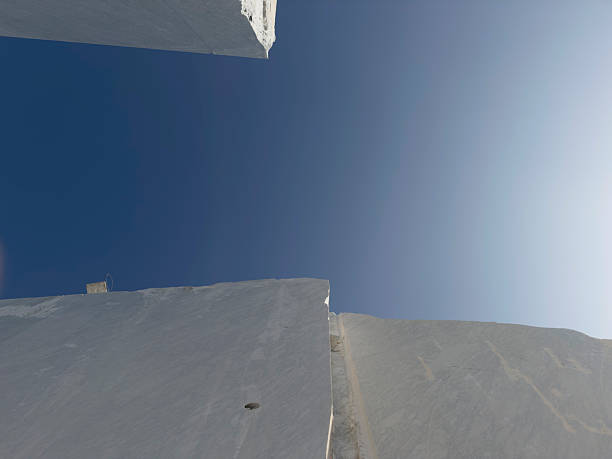 Modern architectural elements featuring smooth concrete curves framing a view of clear blue sky. The minimalist design emphasizes clean lines and open space, suitable for contemporary art or architecture projects.