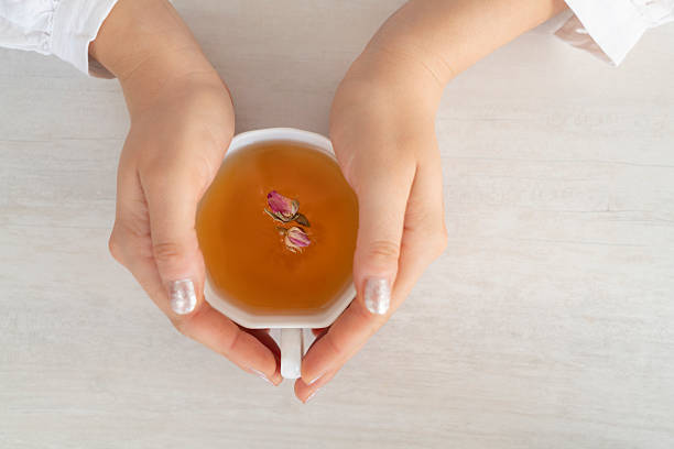 Female hands holding a mug of hot tea. top view