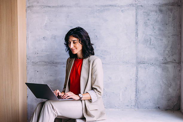 Professional Woman Typing on Laptop in Modern Minimalist Workspace