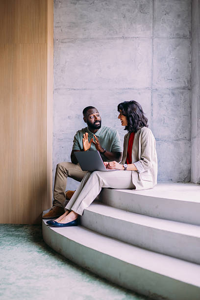 istock Colleagues Discuss Project on Laptop in Modern Office Setting 2220578634