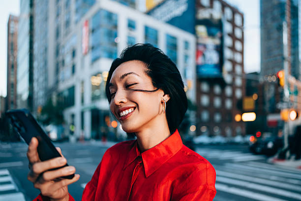 Urban Woman Smiling While Checking Phone in City Environment