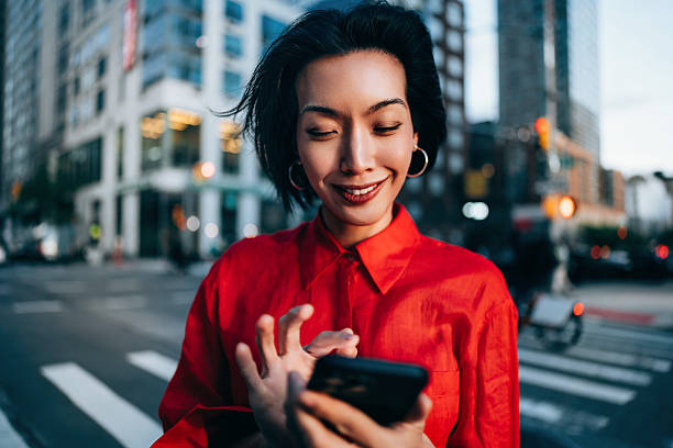 istock Businesswoman in Urban Setting Using Smartphone at Sunset 2220579984