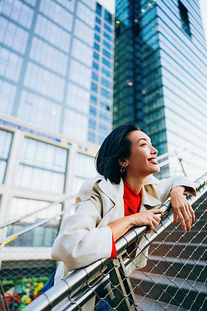 istock Confident Woman Smiling Outdoors Against Modern Urban Skyscraper Architectural Background 2220579994