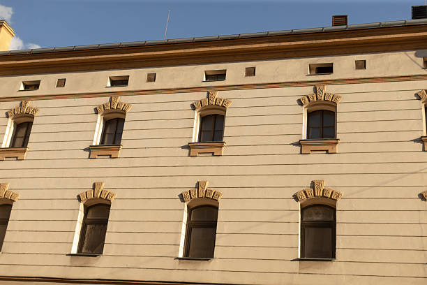 The beautifully detailed facade of a historic building prominently showcases its intricately designed windows and various architectural elements that highlight its rich heritage