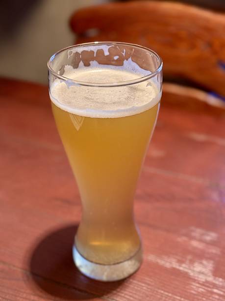 istock Enjoy a refreshing craft beer experience in a cozy and inviting setting, perfect for relaxation. A glass of golden craft beer on a rustic wooden table, ideal for relaxation and enjoyment with friends 2220581610
