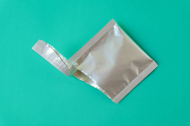 Open aluminum bag lying on color background.
