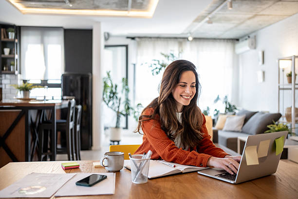 istock Young woman working from home on laptop smiling at the screen 2220587265