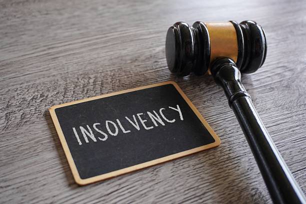 istock A judge's gavel and a chalkboard with text INSOLVENCY. 2220587492