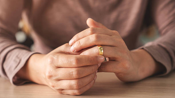 istock Woman takes off an wedding ring 2220590945