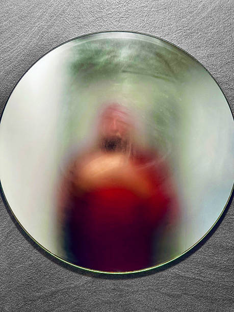 The obfuscated mirror makes it impossible to discern who the reflecting mysterious man is.