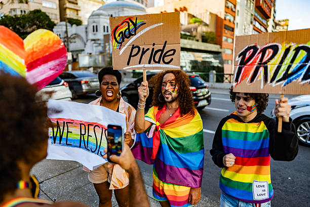 istock LGBTQ+ group protesting with pride signs while being filmed in the city 2220592764