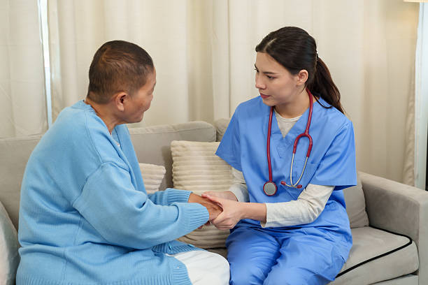 istock Physiotherapist sits with elderly patient, holding hands with care, engaging in calm conversation that fosters emotional well-being and strengthens the therapeutic bond. 2220593018