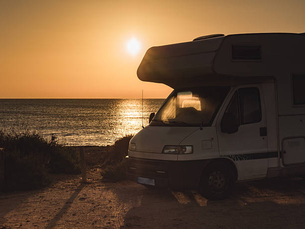 istock Camper vehicle on beach at sunrise 2220596121