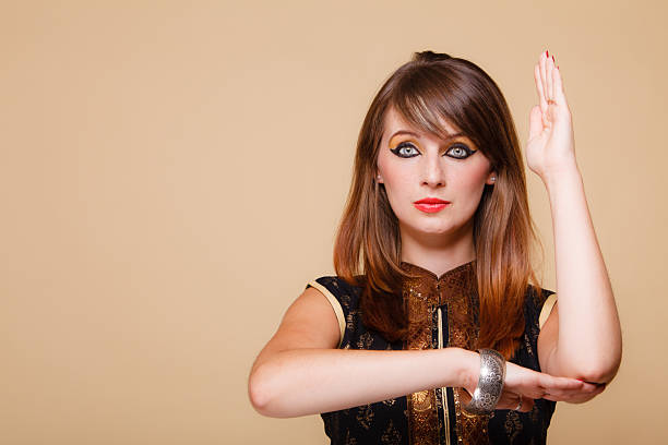 Sensual young fashion woman standing against green stucco wall background