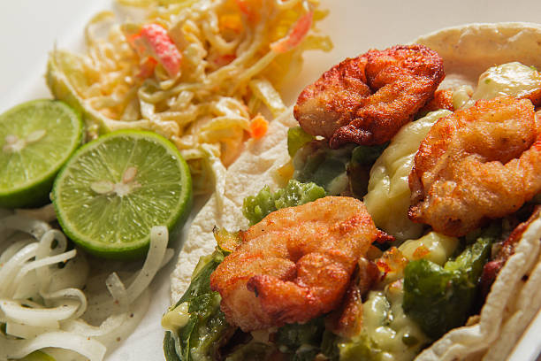 istock This vibrant image presents a shrimp taco plate paired with fresh lime and coleslaw, creating an enticing composition filled with flavor and an inviting dining atmosphere. 2220598048