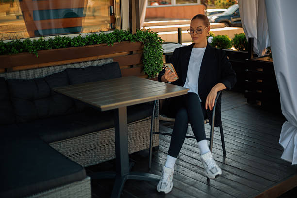 istock Businesswoman using smartphone while sitting at a table in a cafe 2220599139