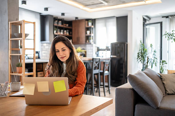 istock Focused businesswoman working from home using laptop at dining table 2220599676