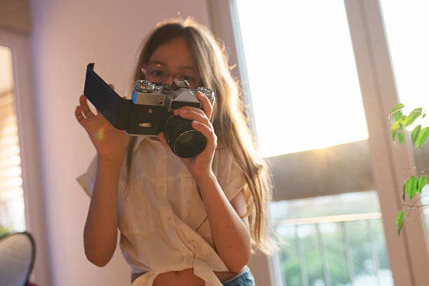 Girl uses an old camera and enjoys it