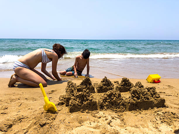 Gulf Shores - Brother and sister add detail to sandcastle - 1991. Scanned from Kodachrome 64 slide.