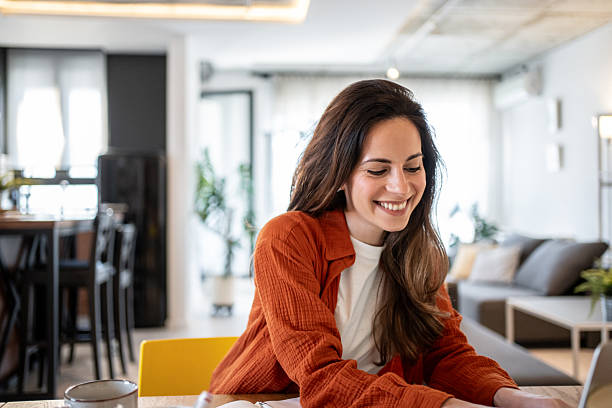 istock Young woman working from home on laptop and smiling 2220599981