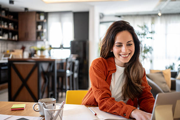 istock Young woman working from home using laptop computer at the table 2220599987