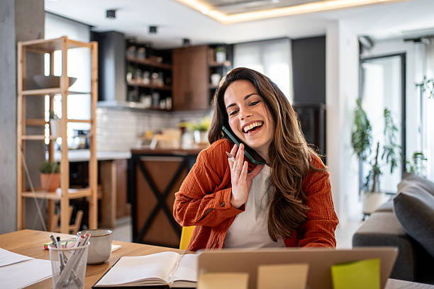 Young woman working from home and talking on the phone