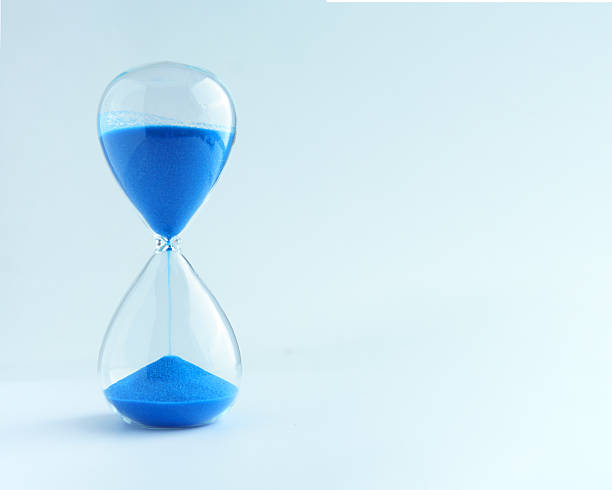 Blue sand timer on light background with copyspace stock photo