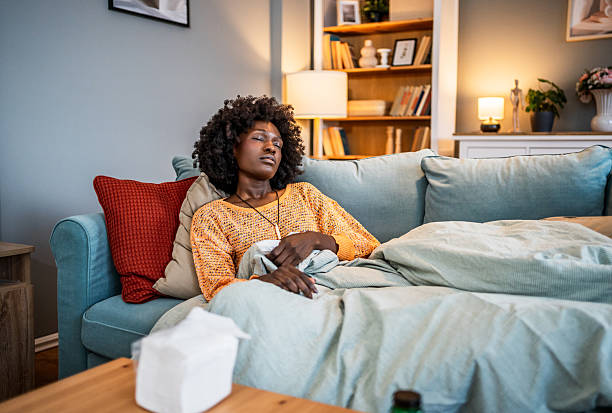 istock Sick young woman resting on sofa at home 2220604259