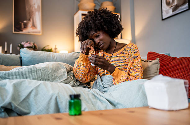 istock Sick young woman taking medicine at home 2220604274