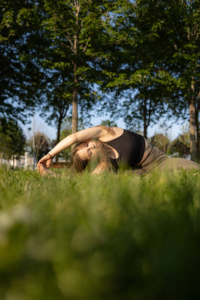 istock Young woman is exercising on the grass at public park. 2220604308