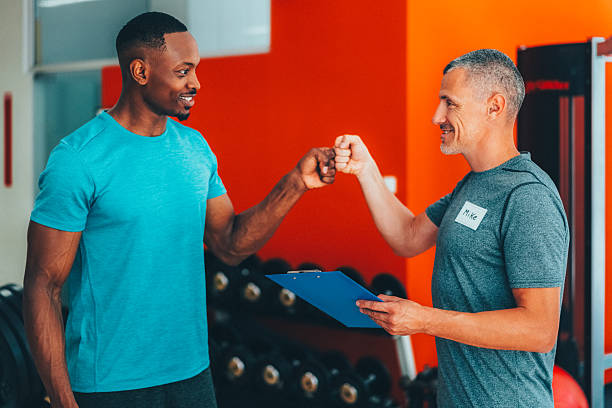 istock Personal trainer greeting his client with fist bump after successful workout 2220607635