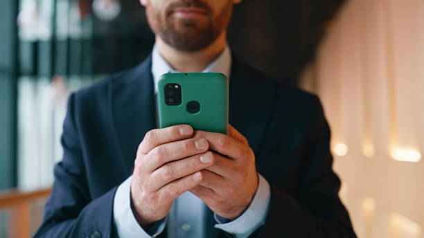 istock Company professional reading sms walking office hallway closeup. Smiling man 2220611038
