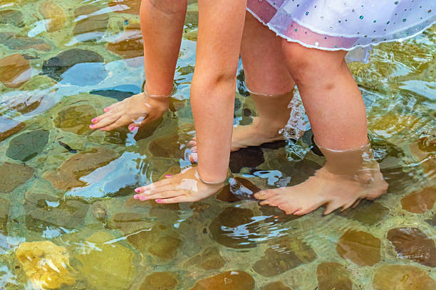 Children's feet and hands in water. Hardening the body in cold water can strengthen human immunity