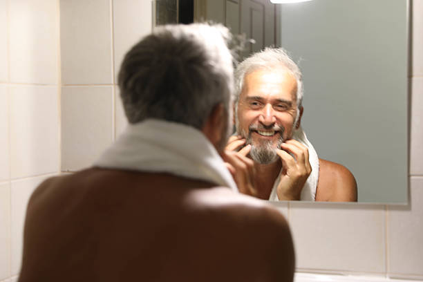 istock Senior man looking herself on mirror in the bathroom at home 2220613712