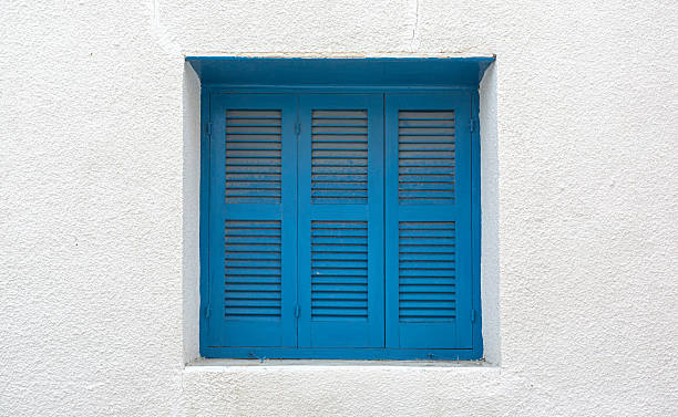 istock Bright blue window shutters decorating white wall in mediterranean style 2220614939