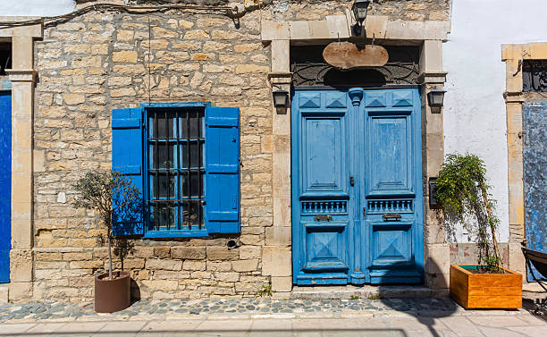 istock Blue door and window shutters adding charm to traditional stone house 2220614964